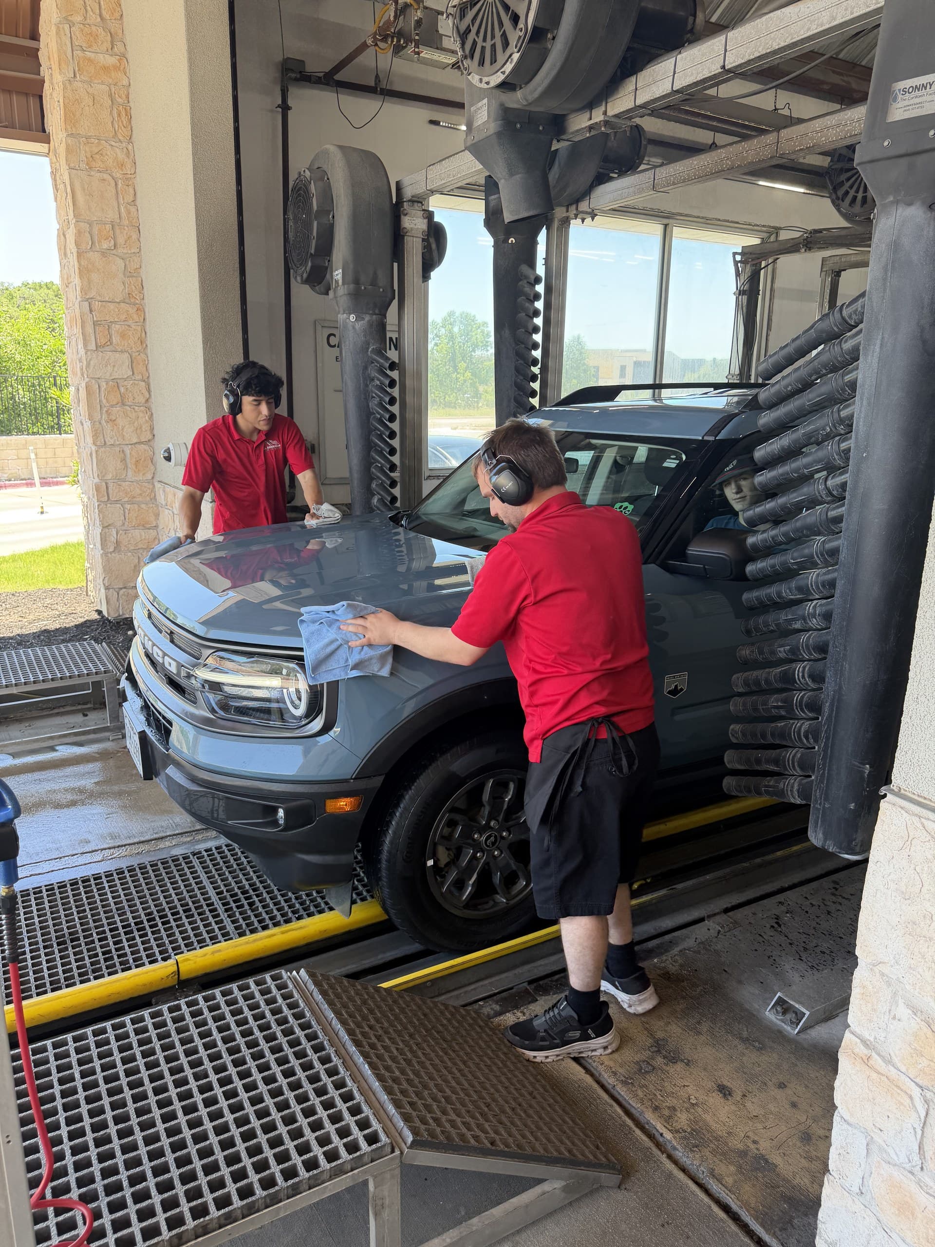 All American attendants hand towel-drying a vehicle as it leaves the tunnel